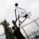 Basketballanlage - Detailaufnahme eines Basketballkorbs während eines Wurfs, perfekt für professionelles Outdoor-Basketballtraining.