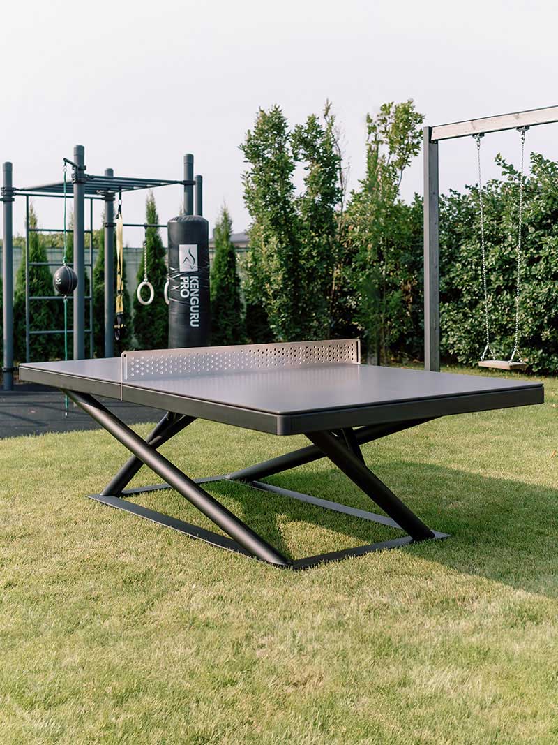 Wetterfeste Tischtennisplatte von Kenguru Pro im Garten mit Calisthenics Anlage und Boxsack im Hintergrund