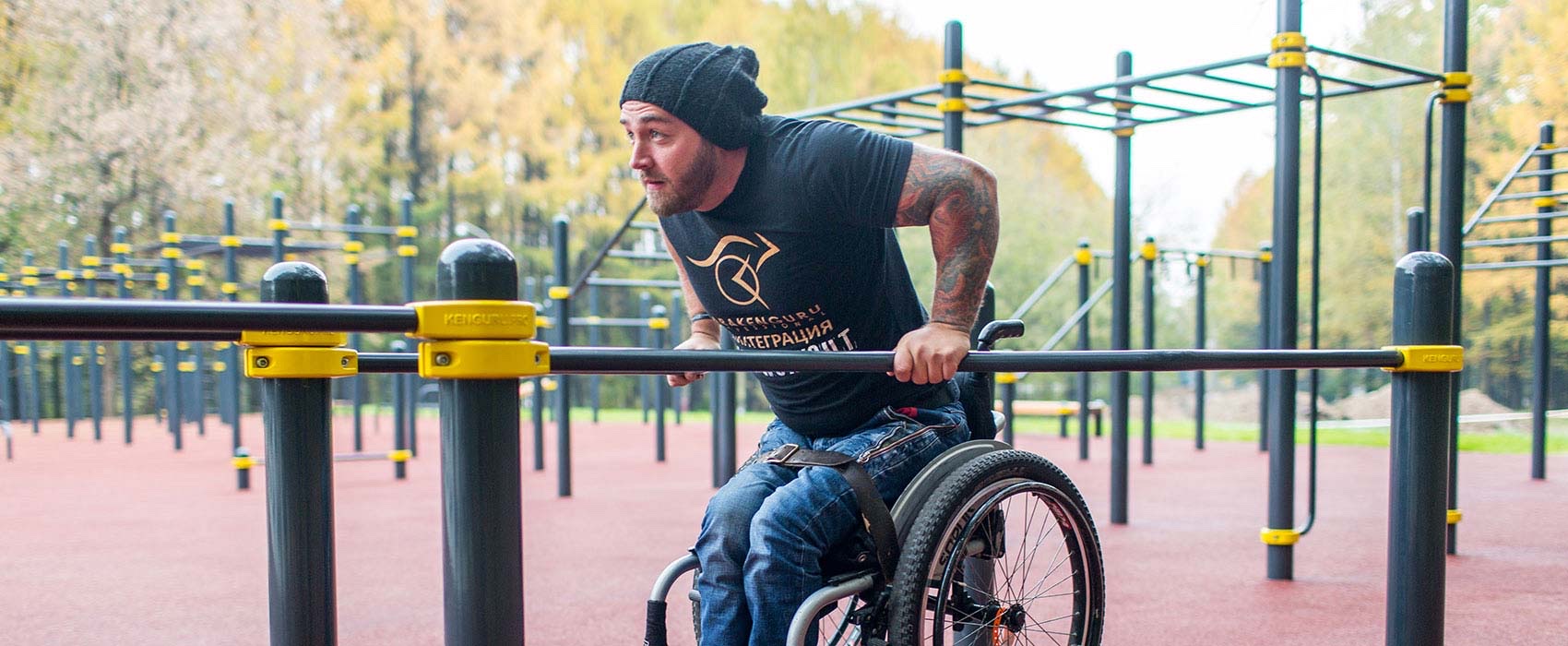 Rollstuhlfahrer trainiert an einer barrierefreien KENGURU PRO Calisthenics-Anlage im Freien