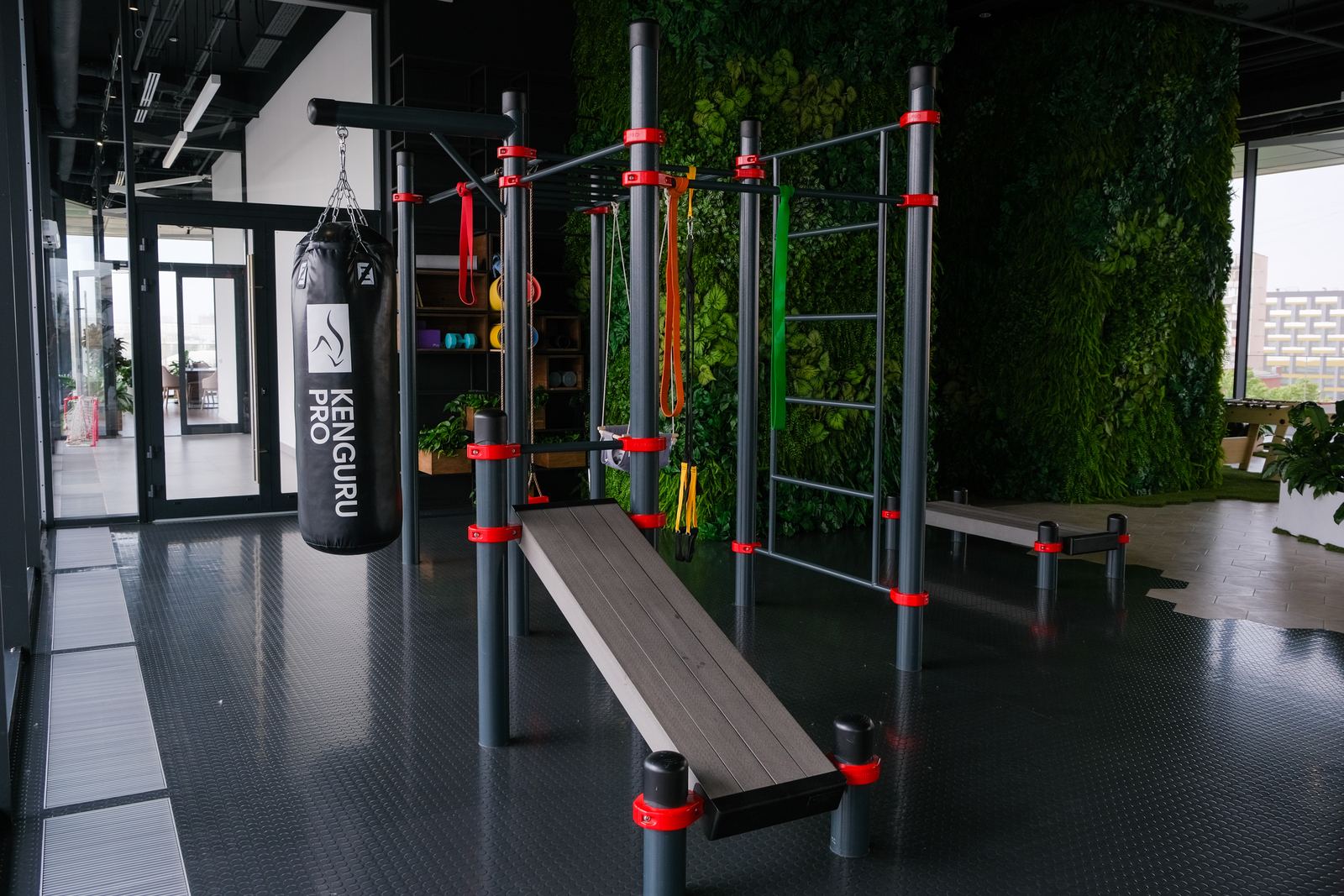 Indoor Calisthenics Station von KENGURU PRO mit Boxsack, Schrägbank und Sprossenwand in einem Innenraum