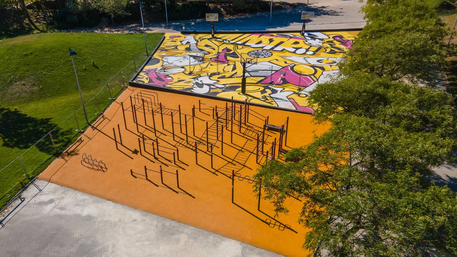 Luftbild eines Calisthenics Parks von KENGURU PRO im Parque das Nações in Lissabon mit Stationen auf Fallschutzbelag neben einem Weg